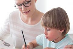 Maman aidant son fils à faire ses devoirs