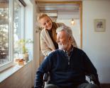 Jeune femme poussant un homme dans un fauteuil roulant