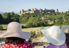 deux touristes aux chapeaux devant la cité de Carcassonne