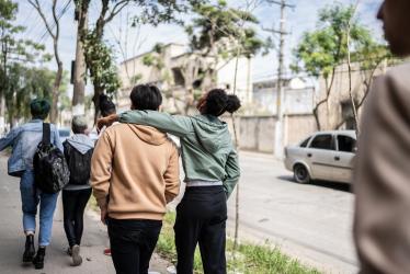 Jeunes de dos en train de marcher bras dessus, bras dessous