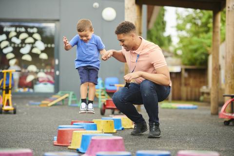 UN ANIMATEUR AIDANT UN ENFANT A SAUTER