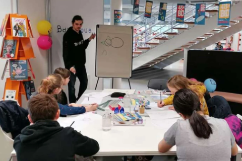 Un dessinateur à l'oeuvre devant des jeunes, lors d'une précédente édition de Sortie de case, dans l'Aude.