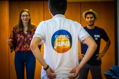 Un jeune vêtu d'un t-shirt du conseil départemental des jeunes