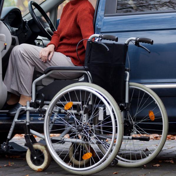 Personne sortant d'une voiture vers un fauteuil roulant 