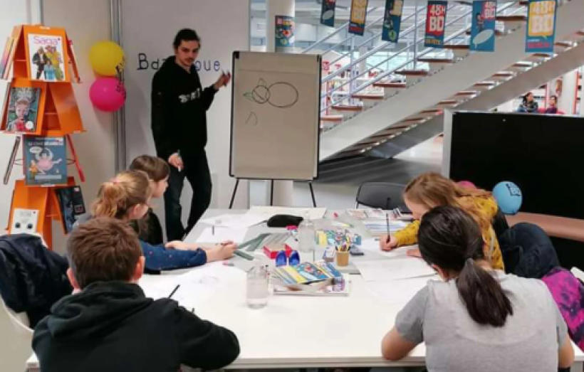 Un dessinateur à l'oeuvre devant des jeunes, lors d'une précédente édition de Sortie de case, dans l'Aude.