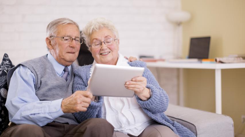 COUPLE DE SENIORS UTILISANT UNE TABLETTE NUMERIQUE