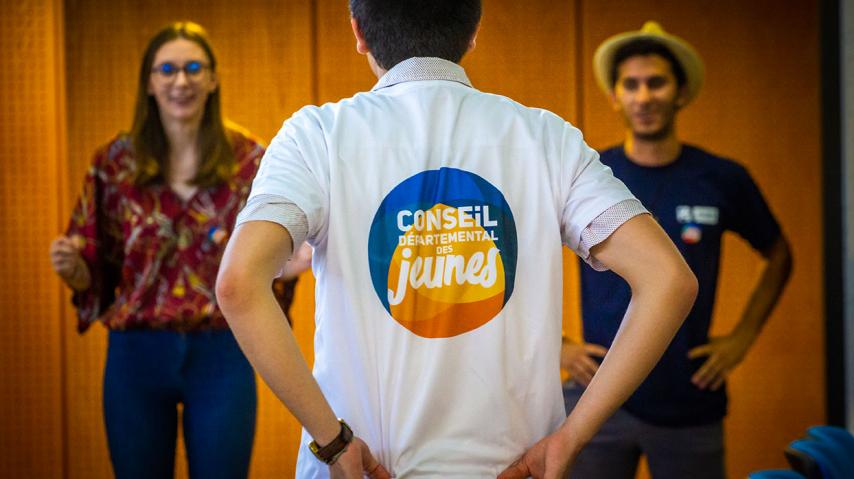 Un jeune vêtu d'un t-shirt du conseil départemental des jeunes